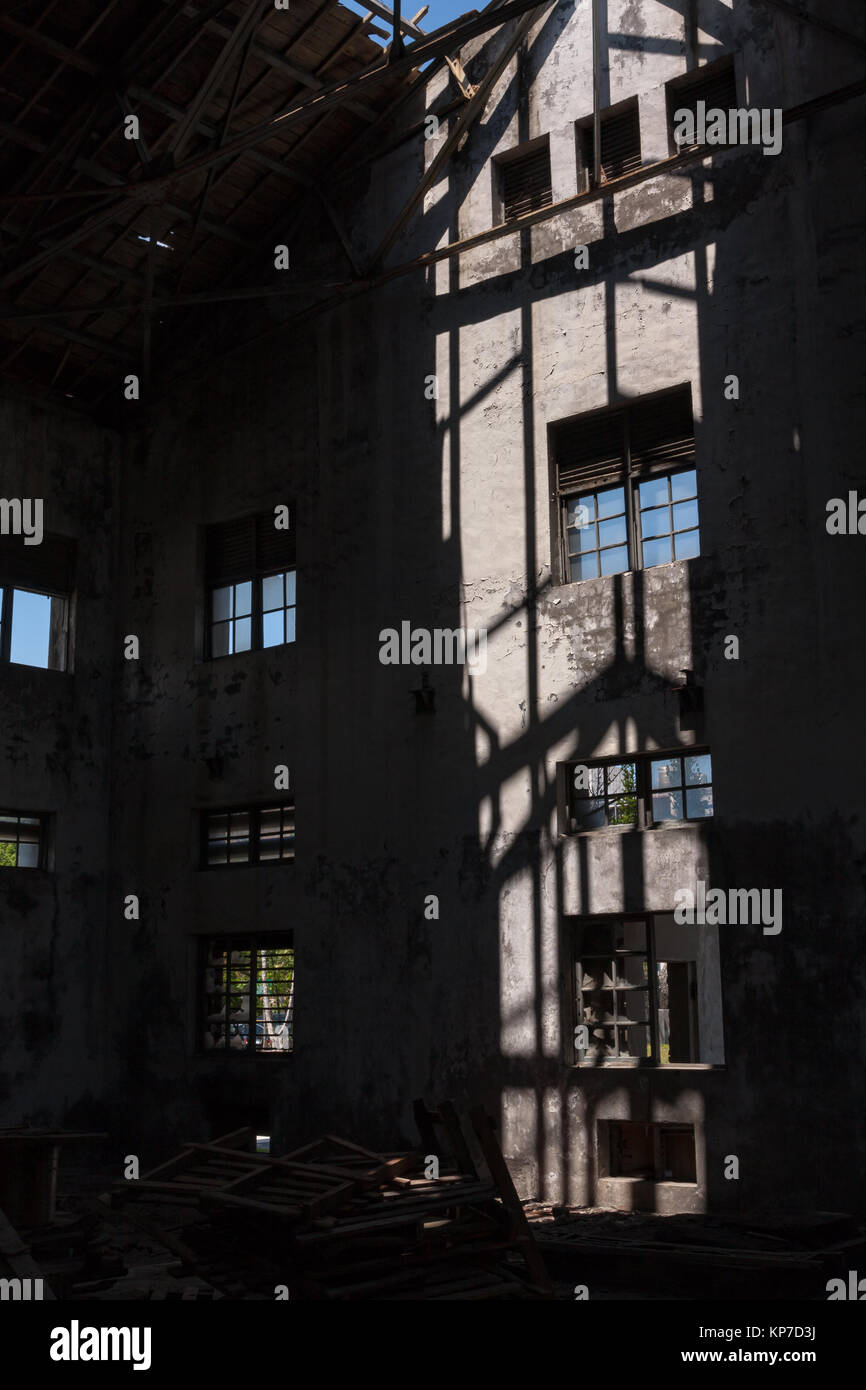 Old abandoned, ruined industry, factory, warehouse; broken and destroyed roof, windows; sunlight and shadow, interior view, Hualien, Taiwan Stock Photo