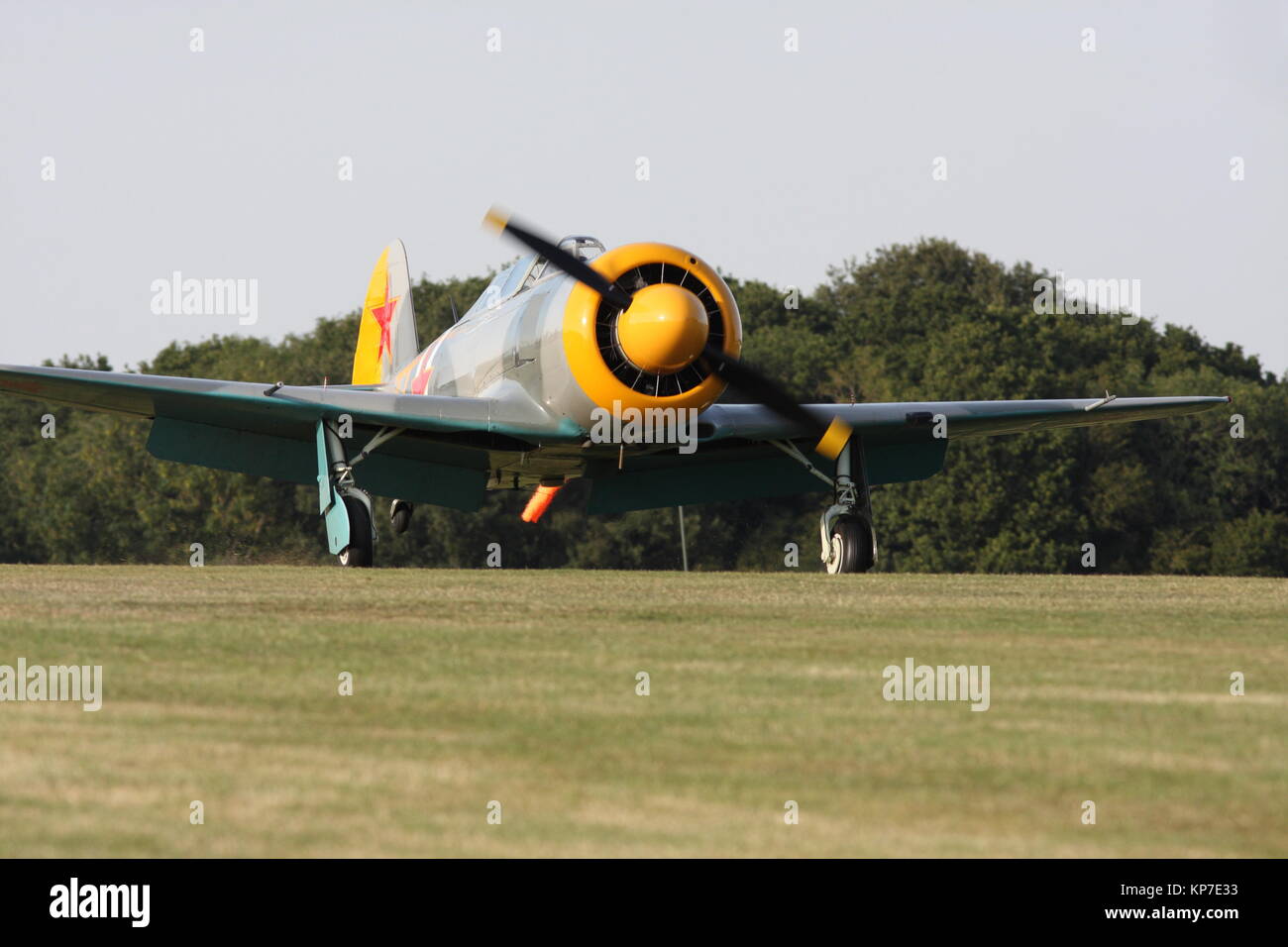 Japanese Yak world war II plane coming in to land on grass runway Stock Photo