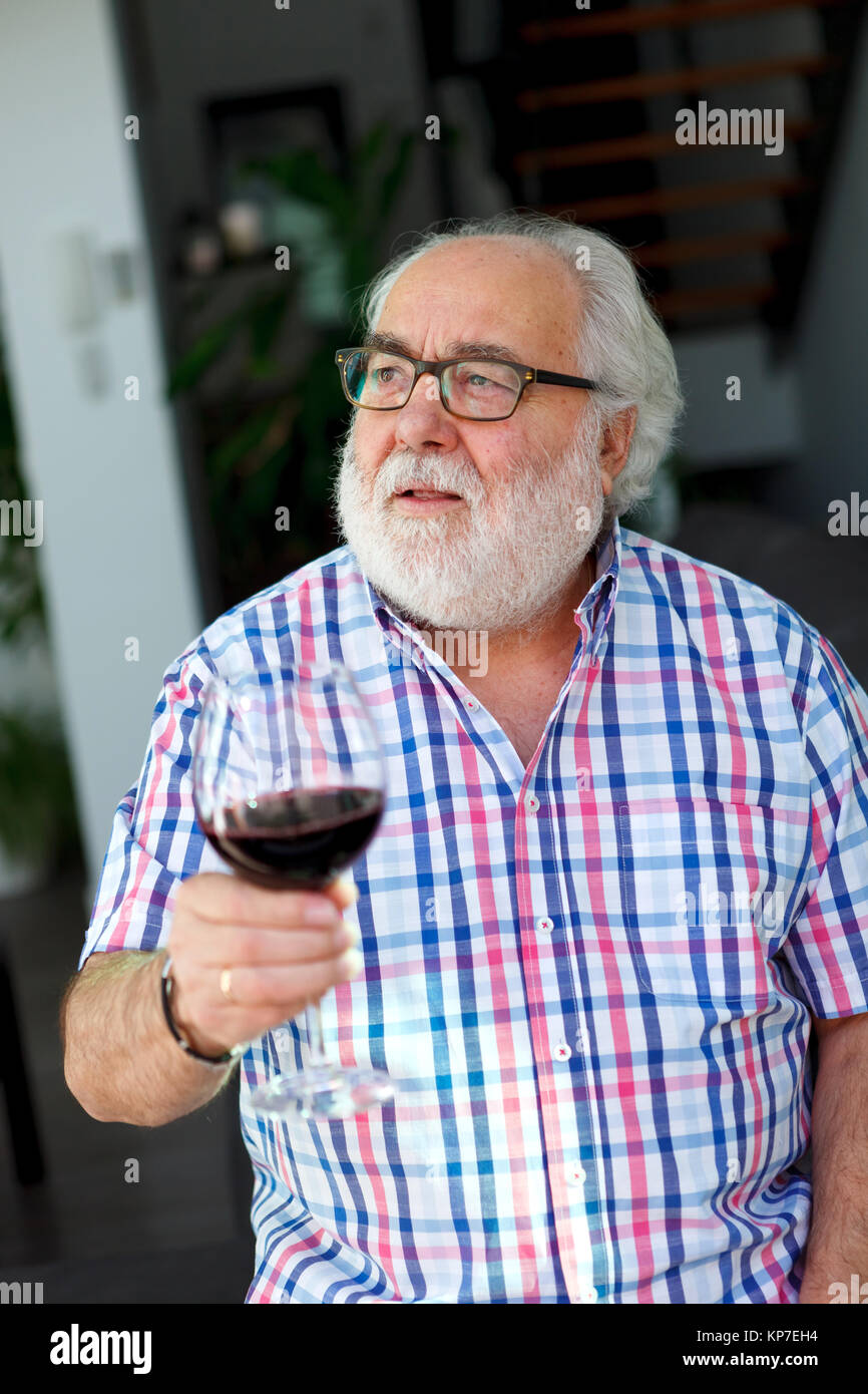 Mature man drinking wine at home Stock Photo - Alamy