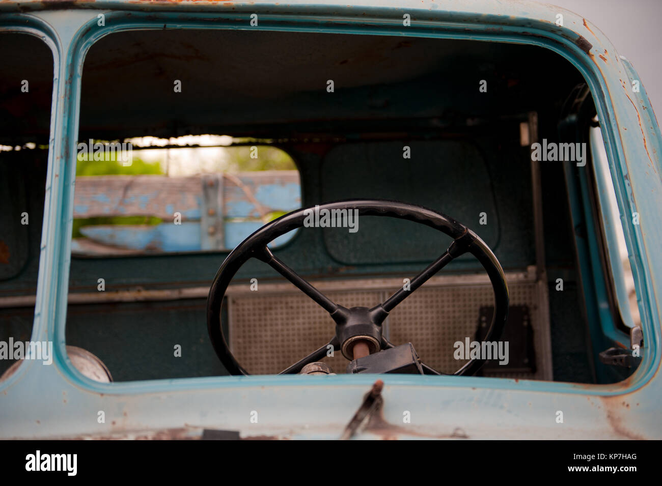 Retro black steering wheel inside old and abandoned blue truck Stock Photo