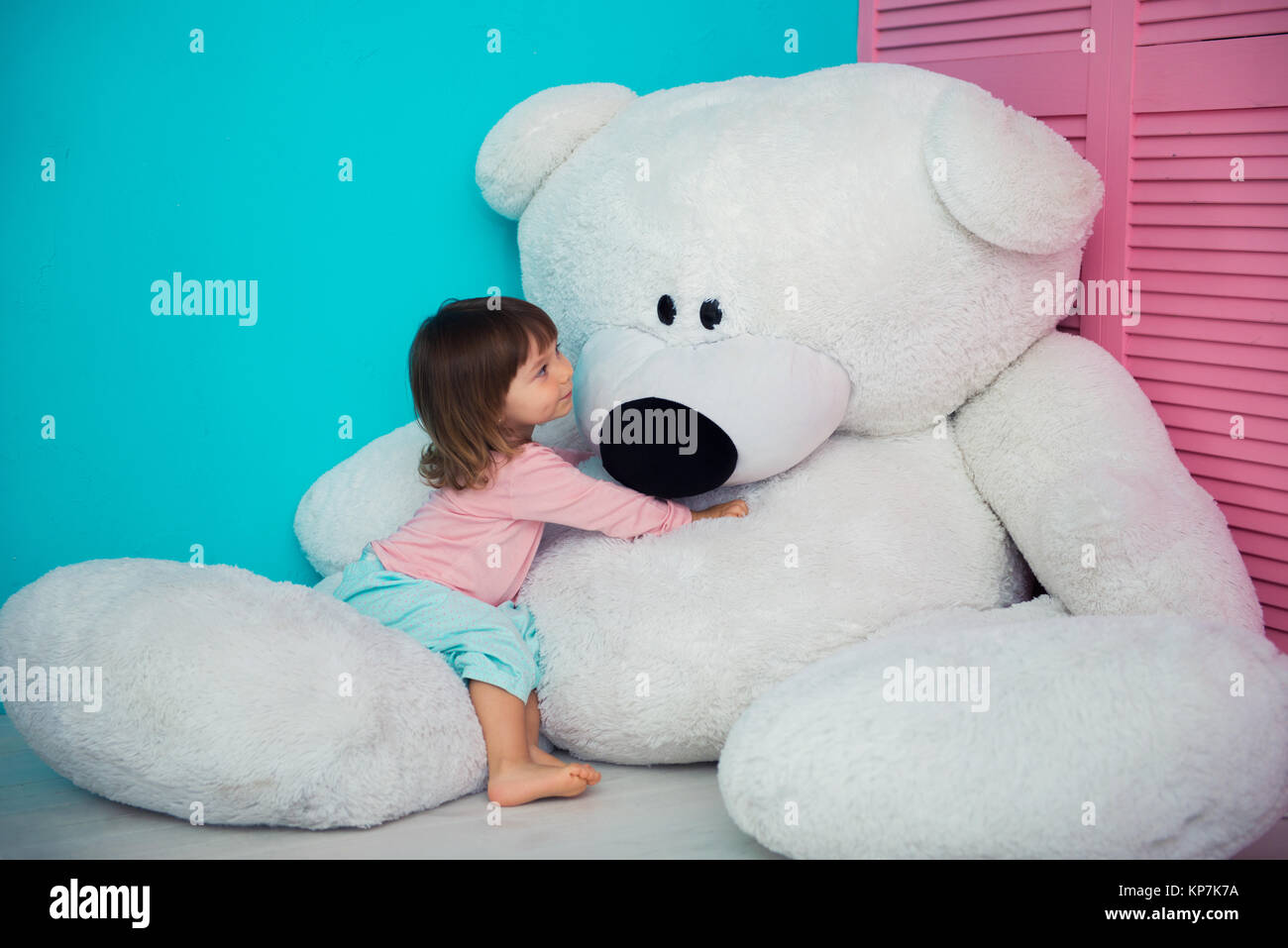 girl hugging huge teddy bear