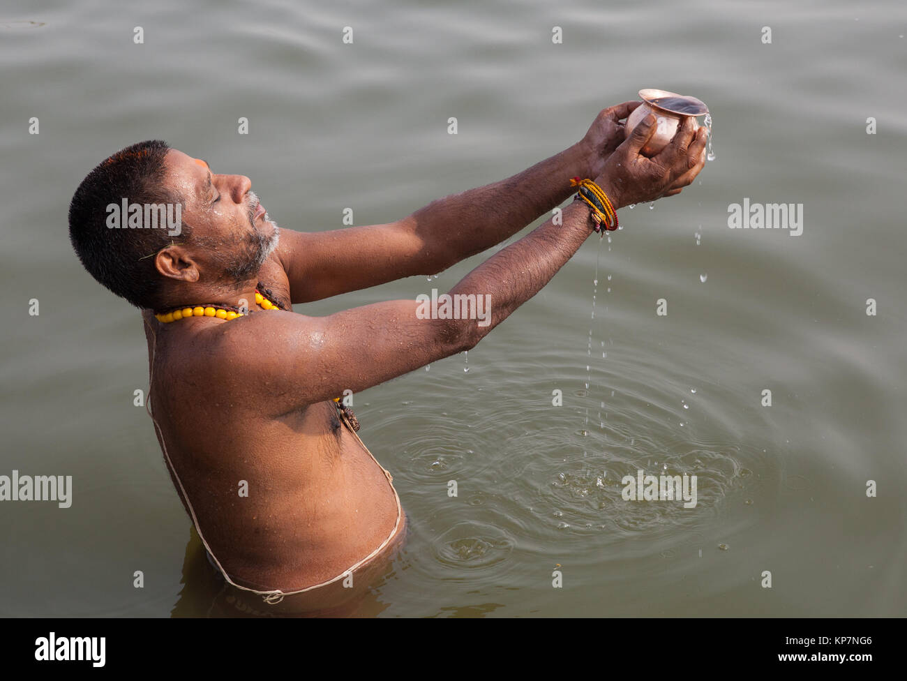 A pilgrim praying in the River Ganges at Varanasi Stock Photo