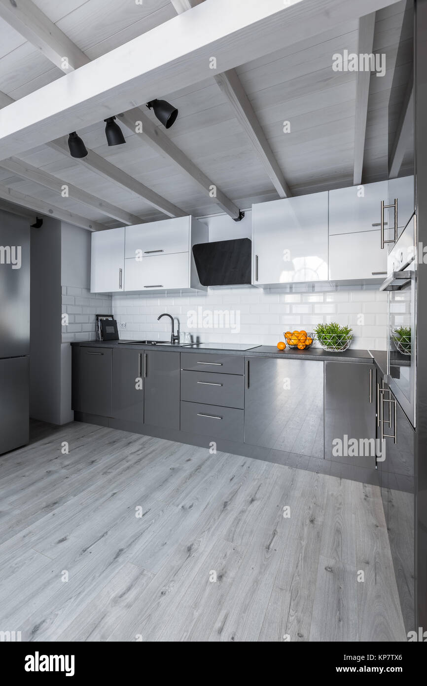 Big contemporary kitchen with white cabinets, metro tiles and gray floor Stock Photo