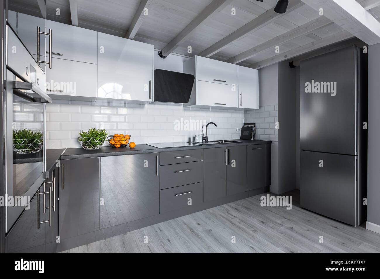 Modern white and gray kitchen with metro tiles and wooden ceiling