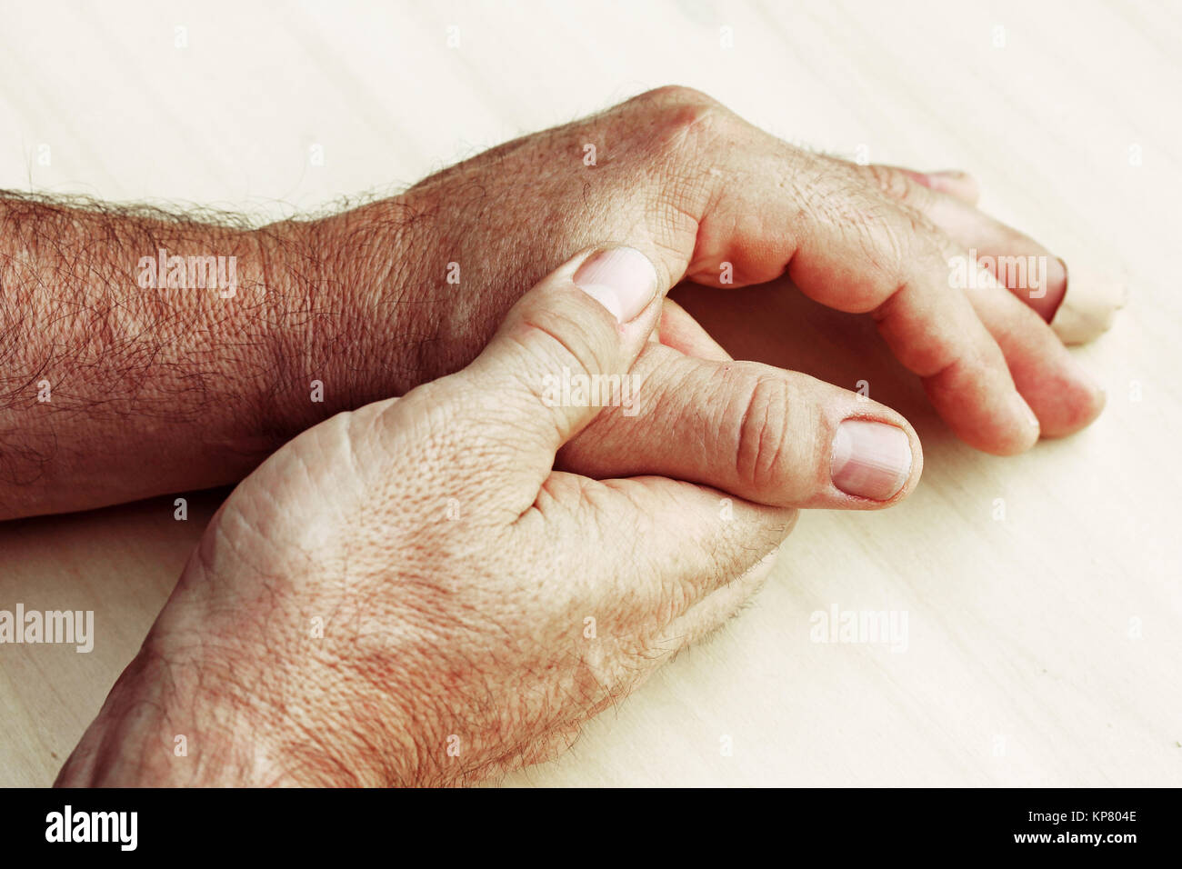 an elderly man has pain in fingers and hands Stock Photo
