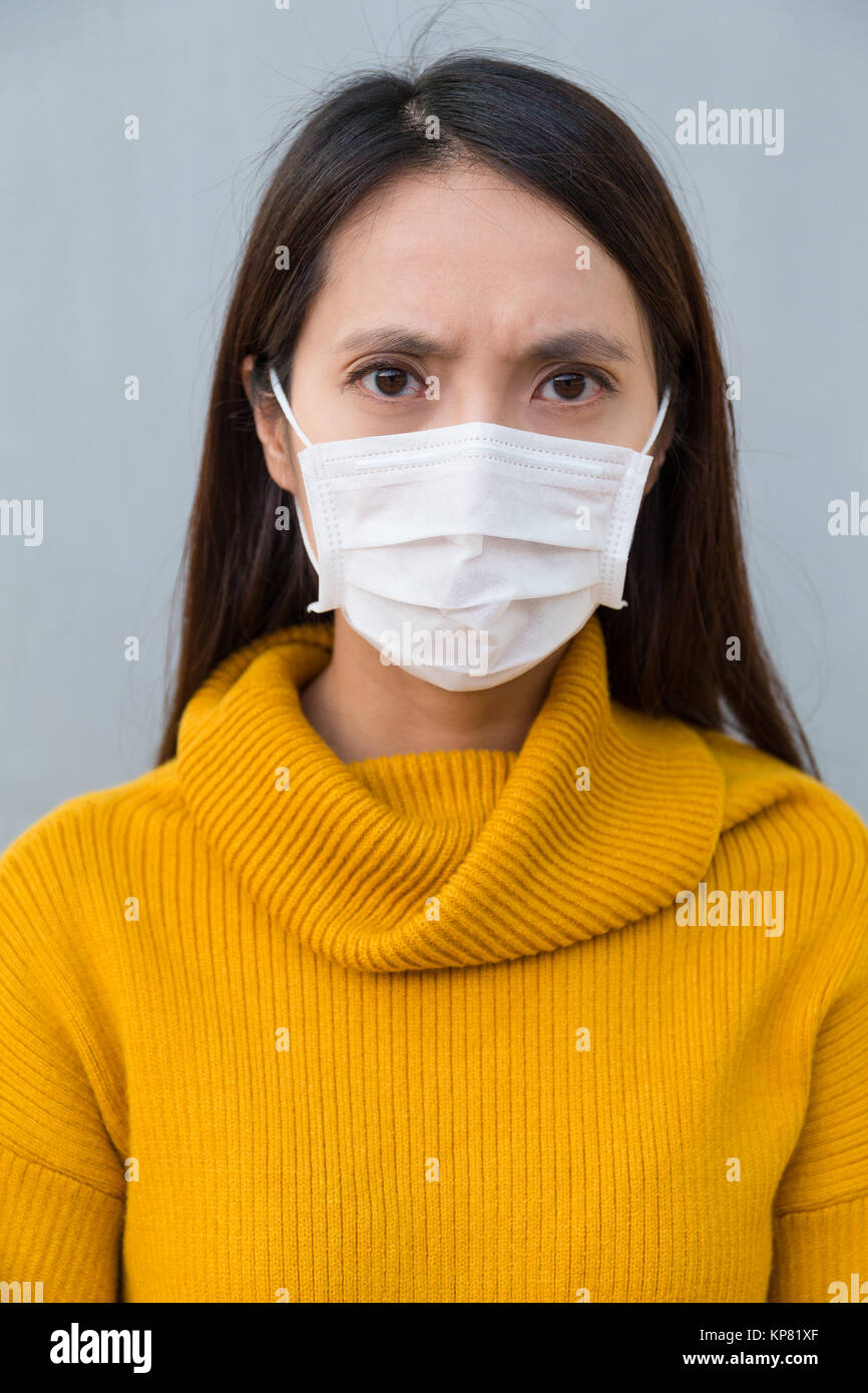 Woman feeling unwell and wearing face mask Stock Photo