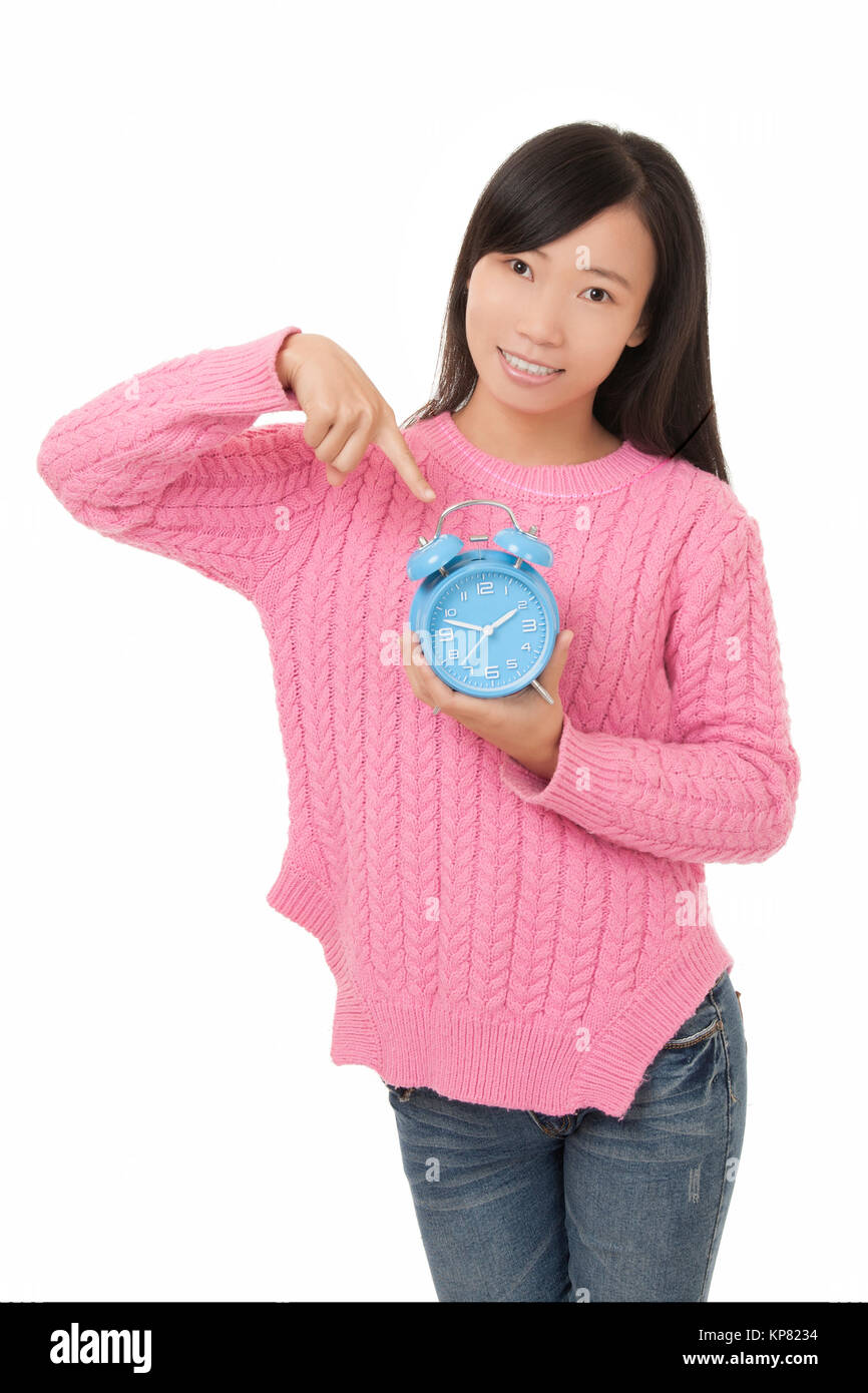 Beautiful Chinese woman holding and pointing at a blue alarm clock isolated on a white background Stock Photo