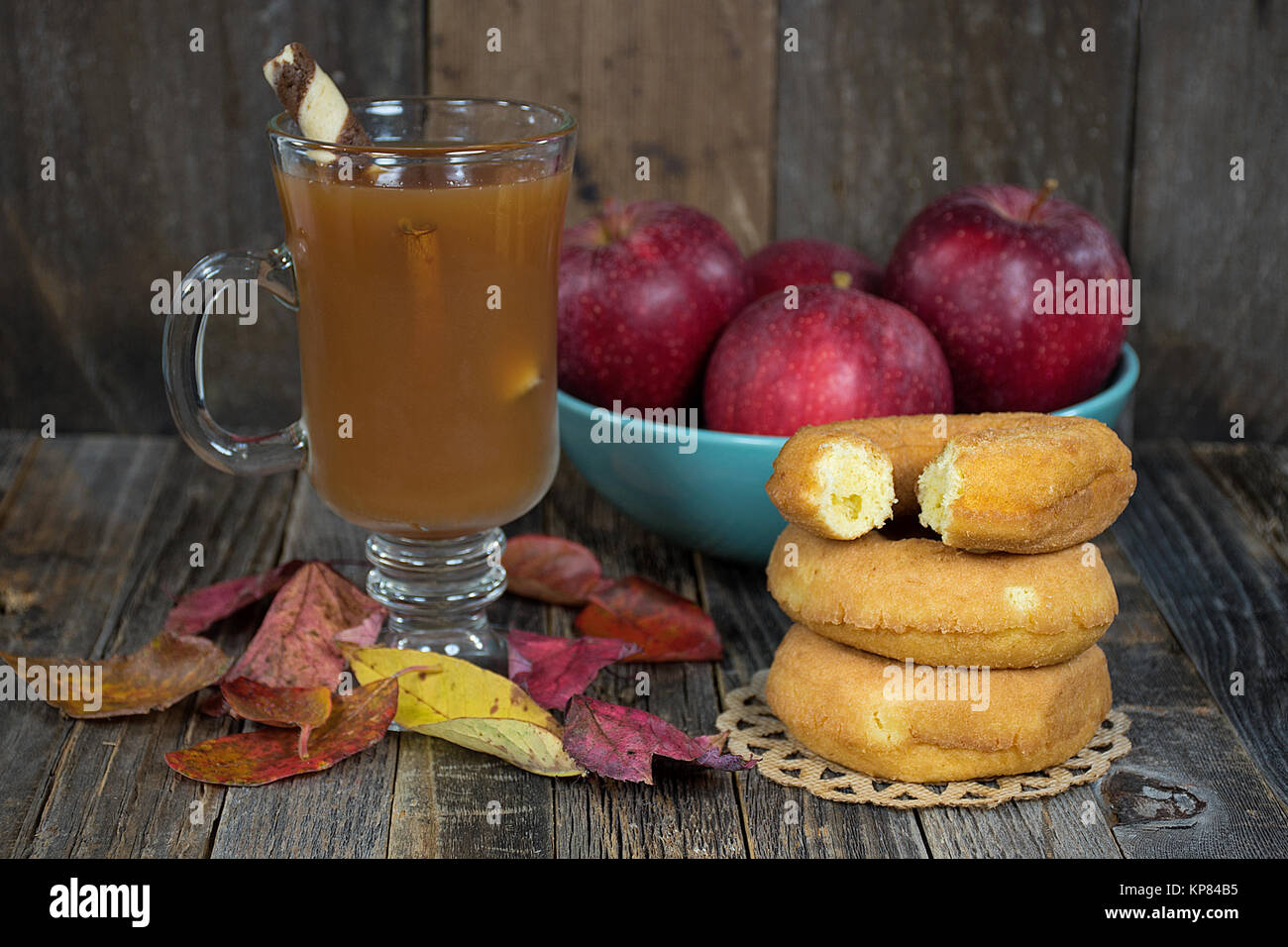 hot apple cider with donuts and red apples in bowl Stock Photo