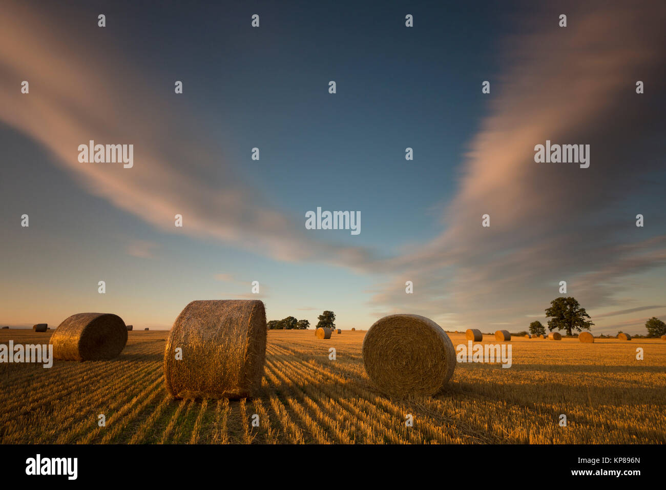 moving clouds on field with straw bales,long exposure Stock Photo