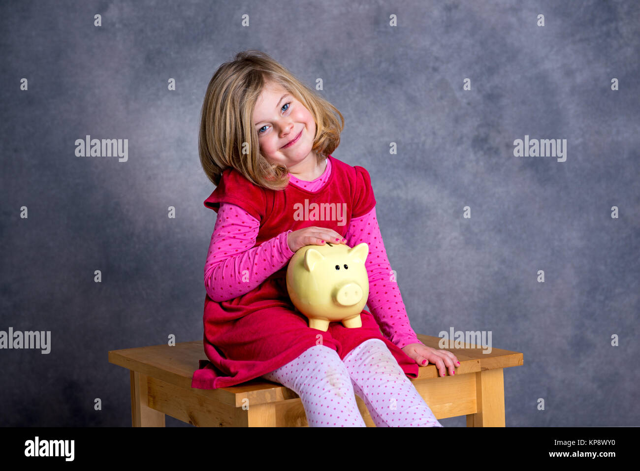portrait of a smiling girl with piggy bank Stock Photo - Alamy