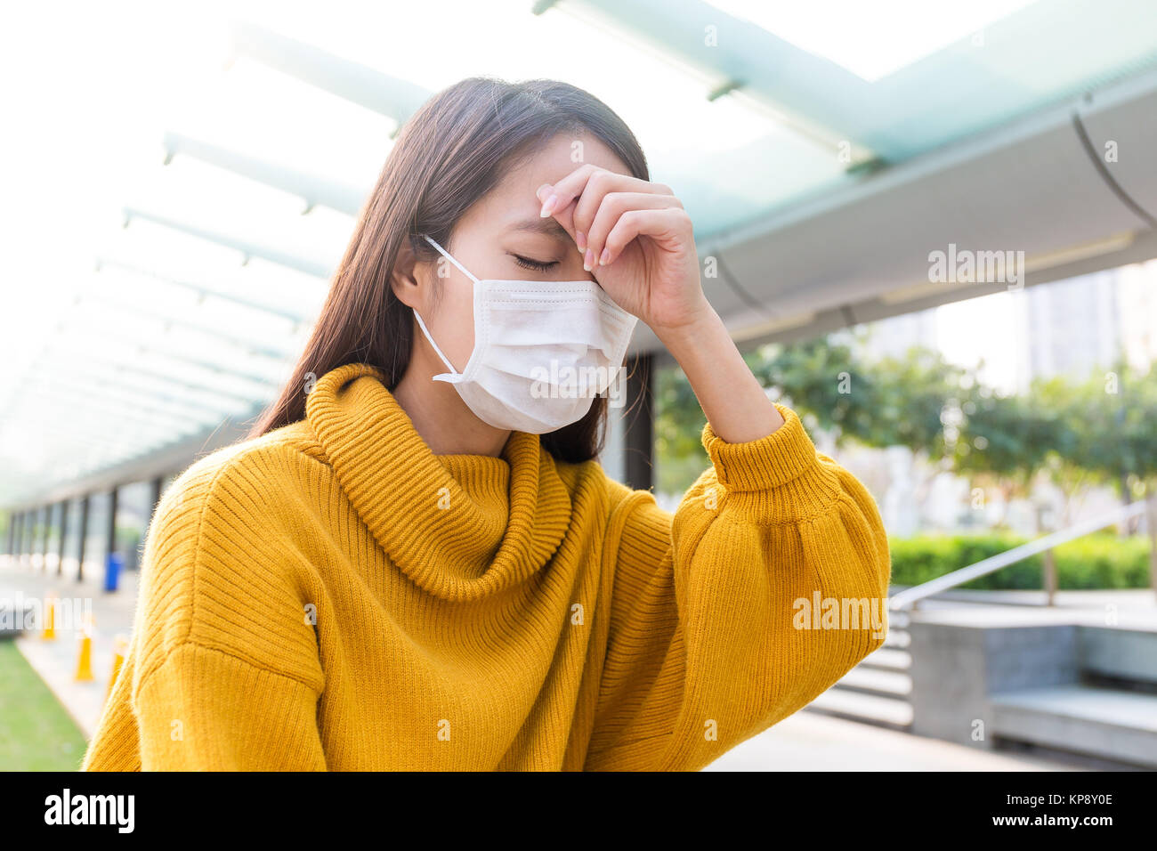 Woman got serious headache and wear face mask Stock Photo