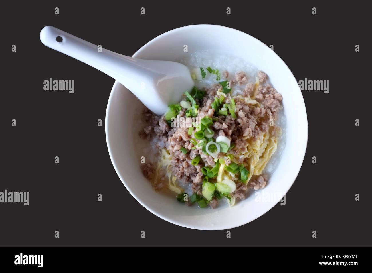 Soft boiled rice with mince pork, Congee in white bowl isolated on black background Stock Photo