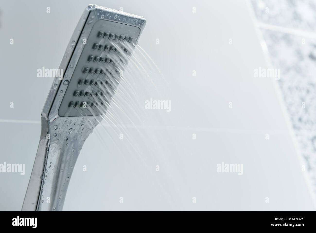 Low water pressure problem closeup at shower head in white bathroom
