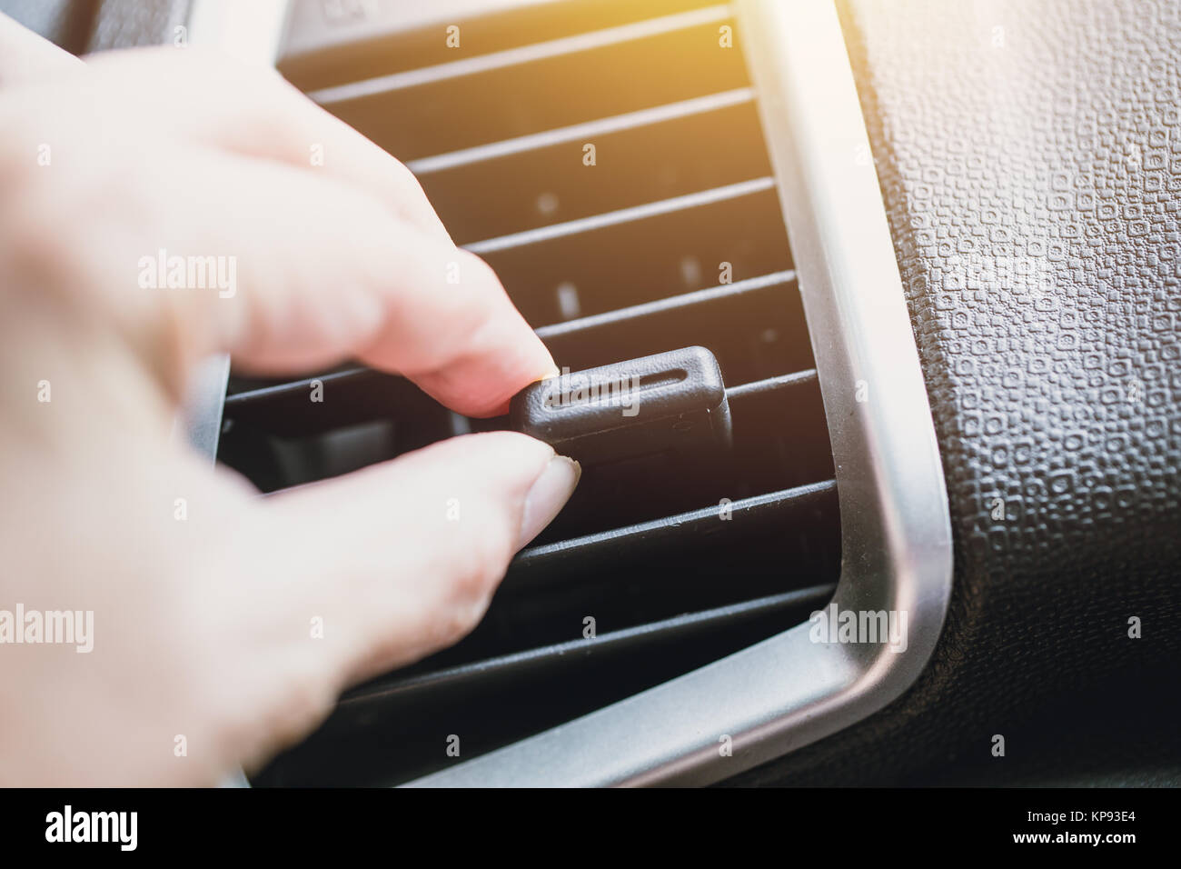 Hand adjust way air vent cooling air flow in car dashboard Stock Photo