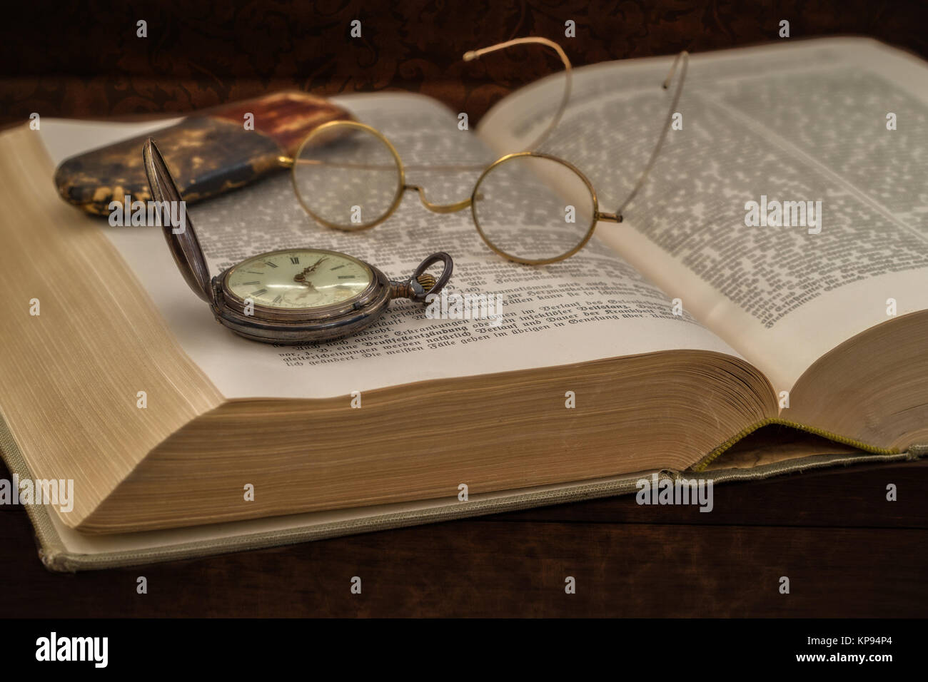 old book with glasses and pocket watch Stock Photo