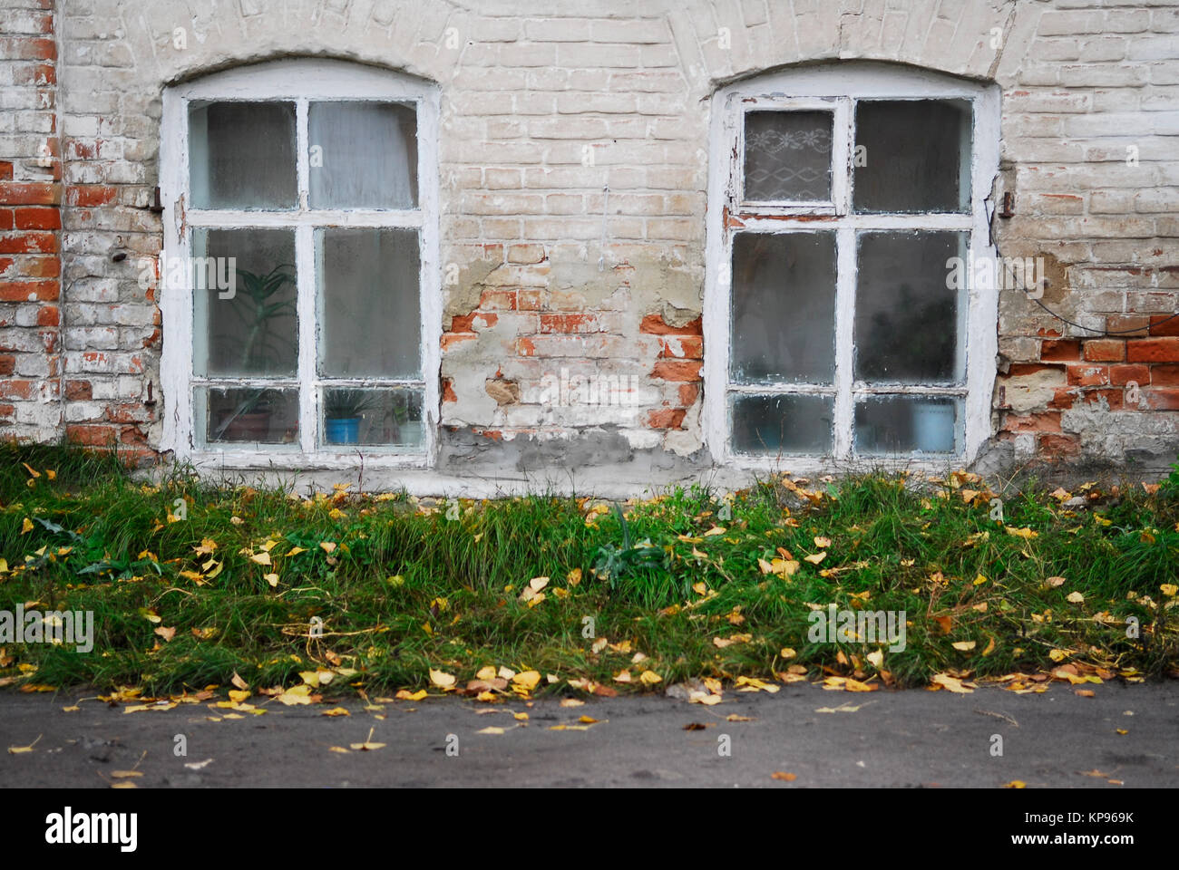 White brick wall of the old house with two wooden windows with vintage ...