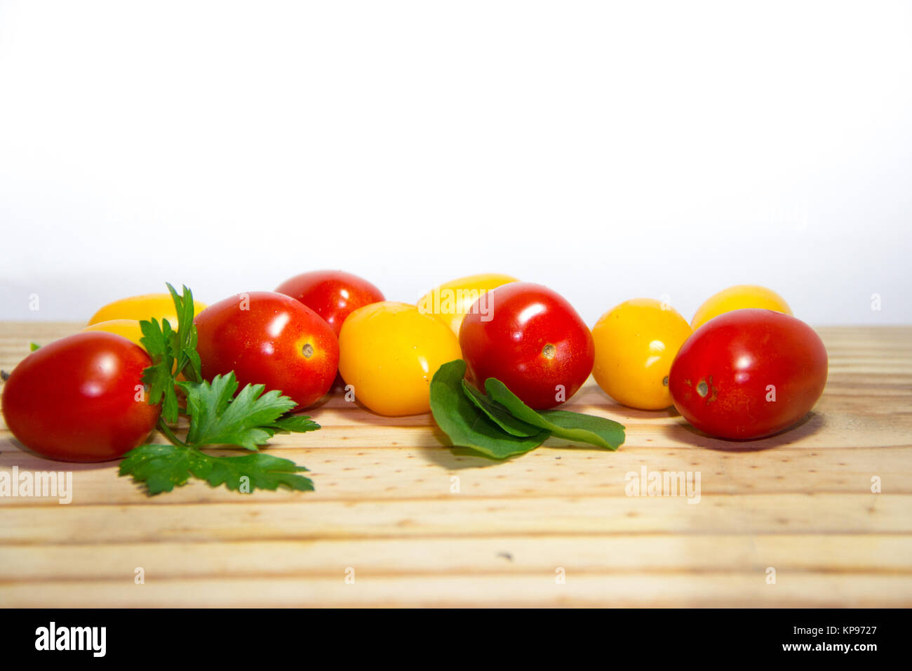red and yellow cherry tomatoes on wooden background Stock Photo - Alamy