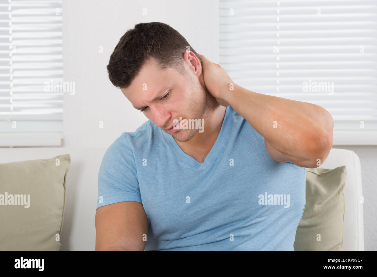 Upset Man Suffering From Neck Pain At Home Stock Photo - Alamy