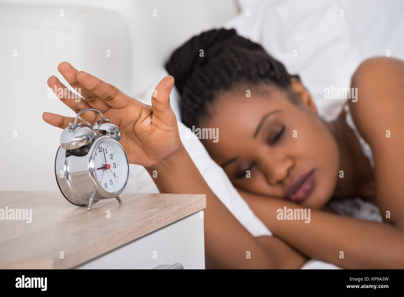Woman Turning Off Alarm While Sleeping On Bed Stock Photo Alamy
