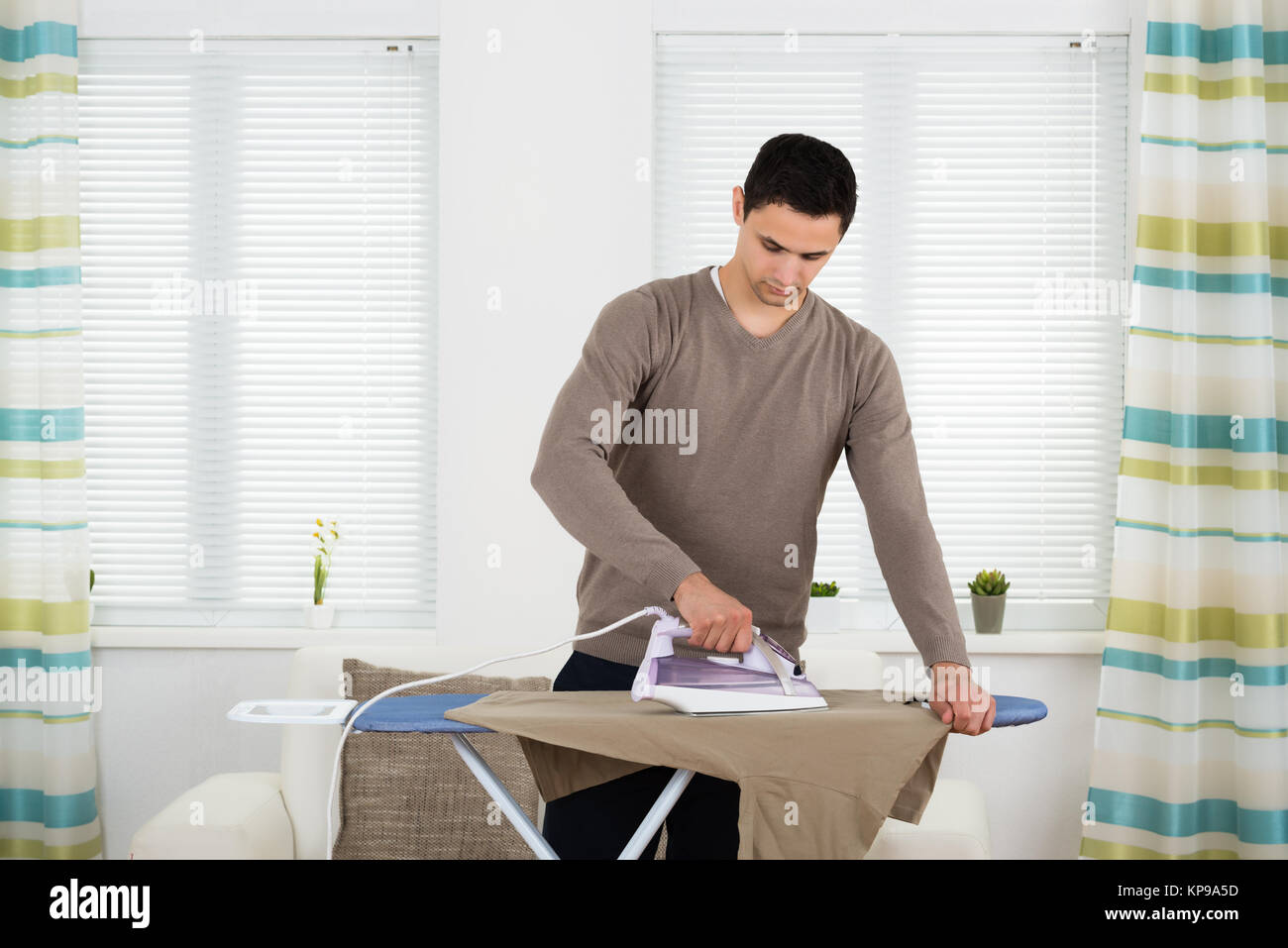 Man Ironing Tshirt On Board At Home Stock Photo - Alamy