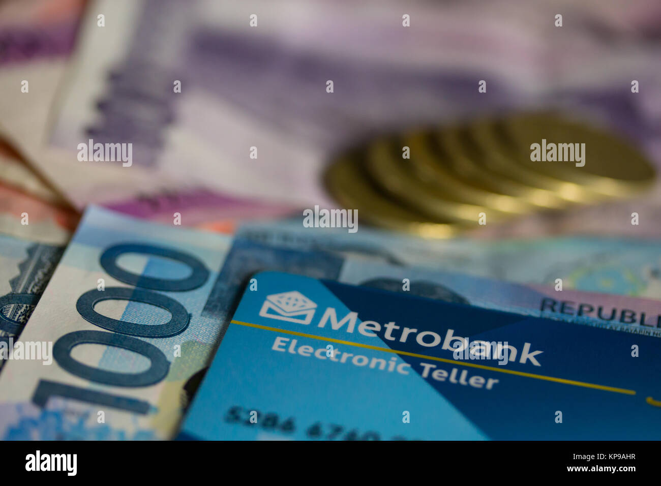 Philippine Metrobank ATM card with Pes bank notes and coins Stock Photo