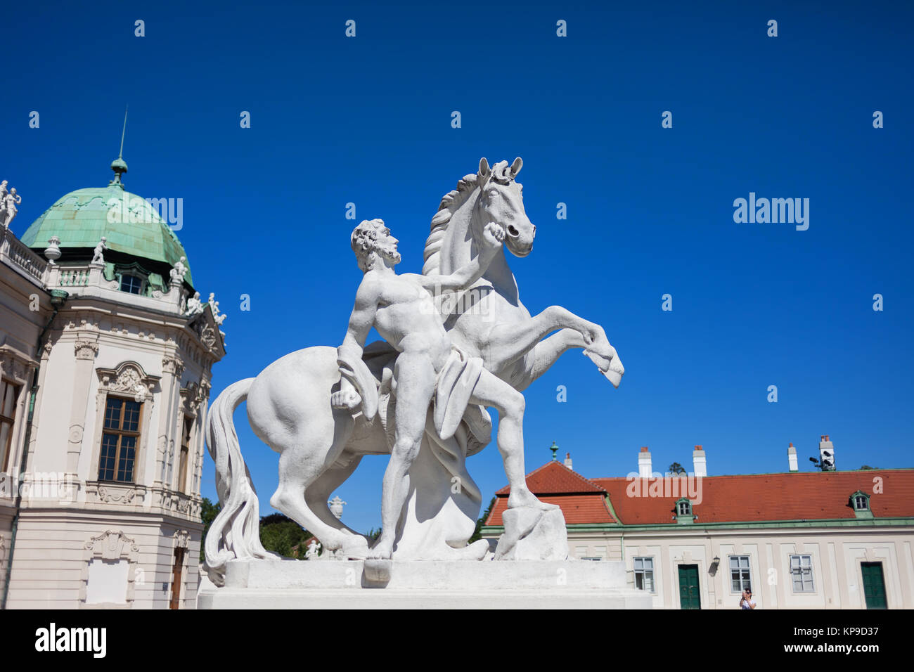 Man with a horse statue in front of Upper Belvedere in Vienna, Austria
