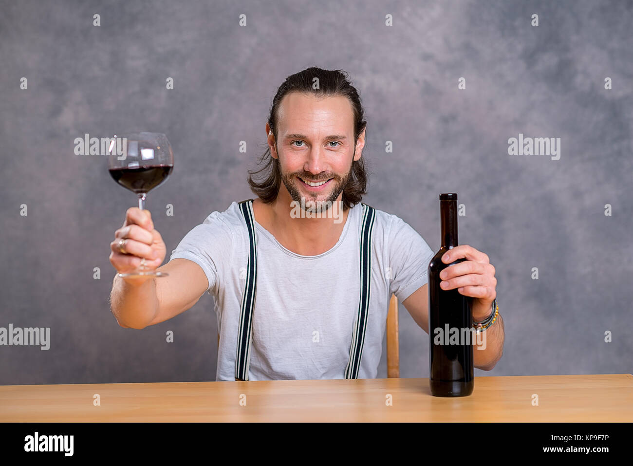 young man sitting at the table and drinking red wine Stock Photo - Alamy