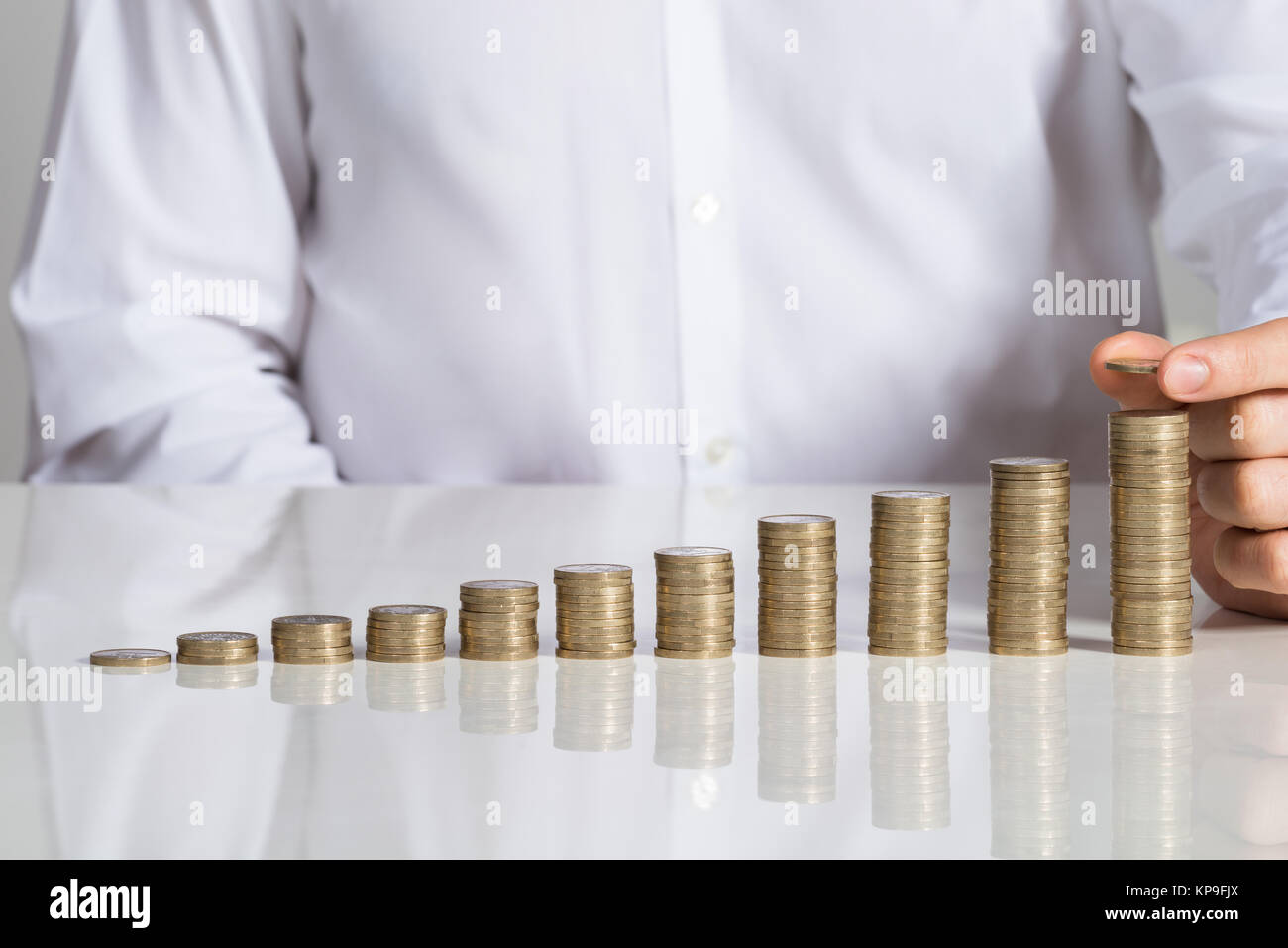 Businessman Stacking Coins At Office Desk Stock Photo - Alamy