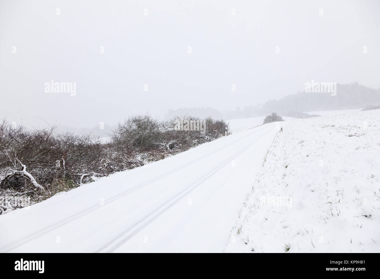 Snow covered road in a snowy white winter landscape Stock Photo