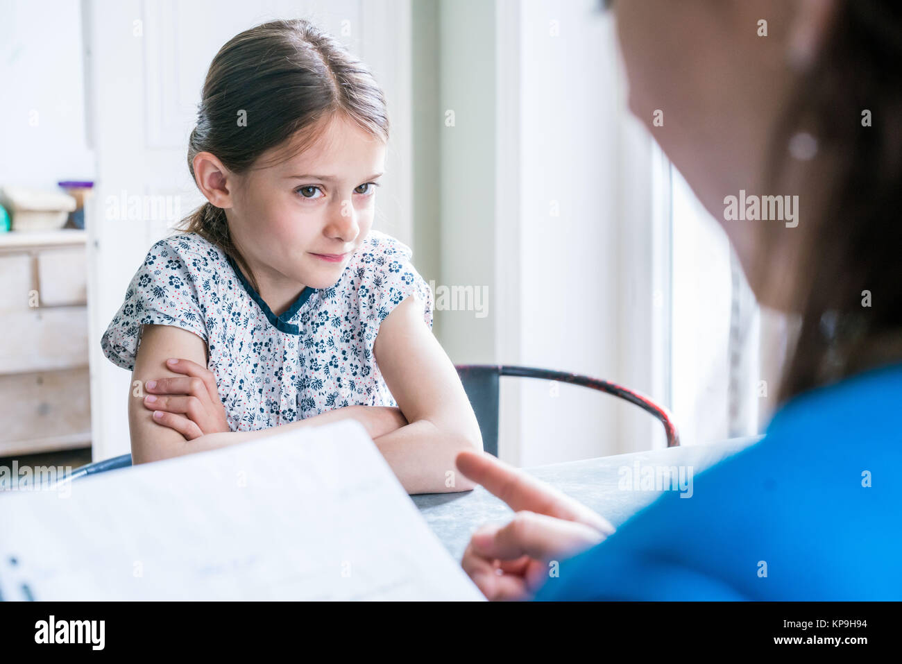 Mother checking the homework of her 10 yearold daughter Stock Photo