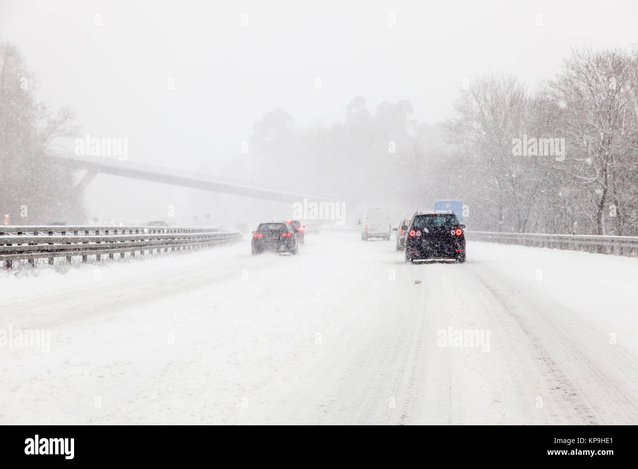 Cars driving on a highway covered with snow during a snowstorm in winter Stock Photo