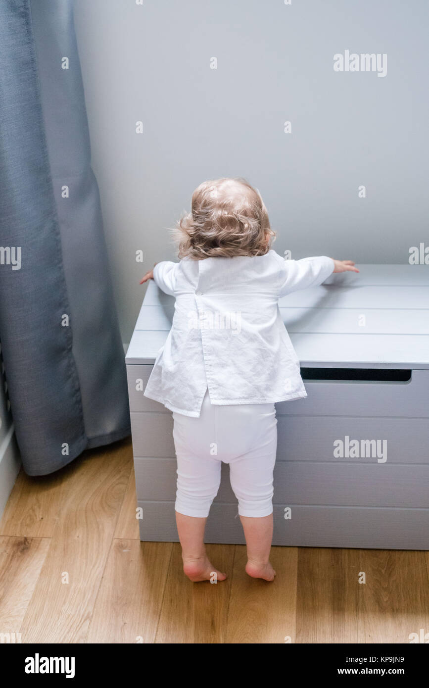 16monthold girl climbing on a toy box Stock Photo Alamy