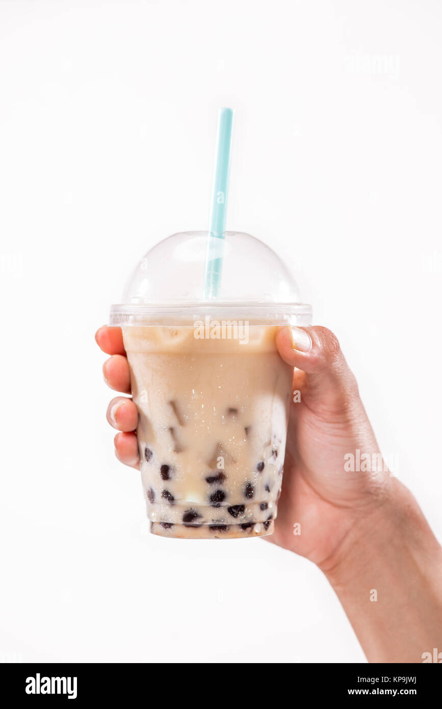 Holding a plastic glass of refreshing Taiwan iced milk tea with bubble