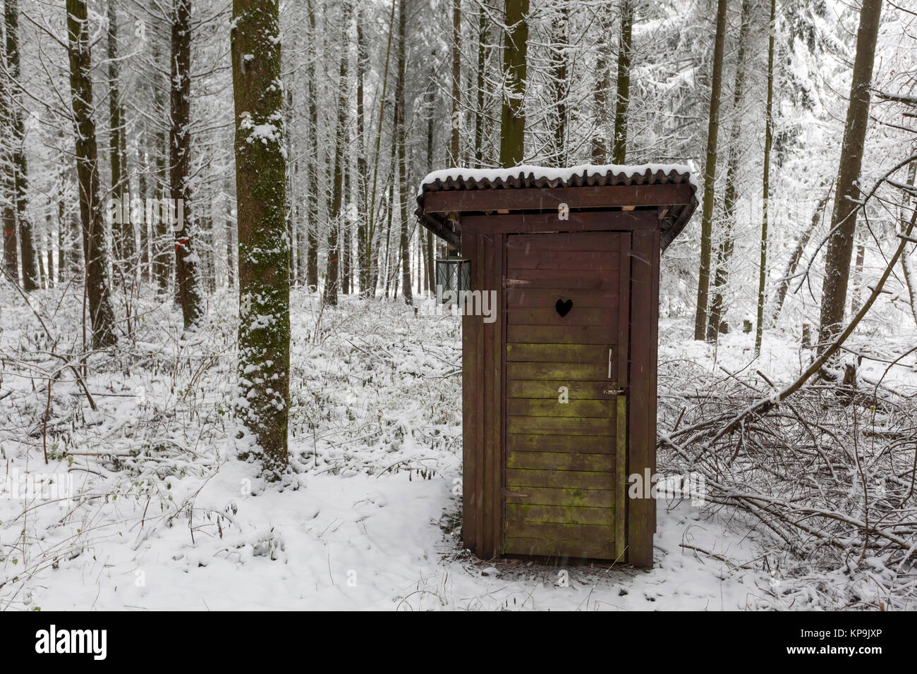 Wooden outdoor toilet in a snowy winter forest Stock Photo