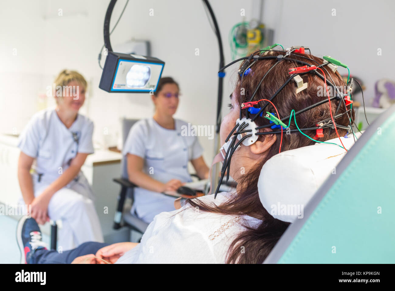Young woman undergoing an electroencephalogram (EEG), epilepsy