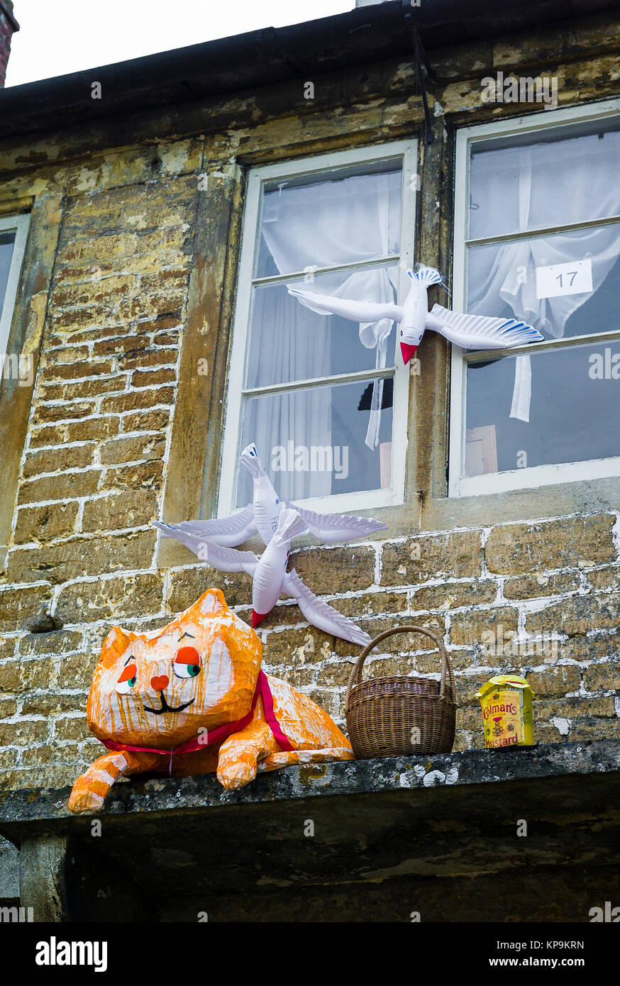 A scarecrow resembling Bagpuss, dreaming about catching birds, one of the entries in Lacock village annual competition in Wiltshire UK Stock Photo