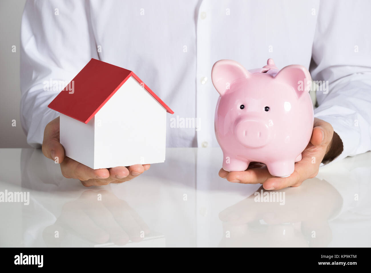 Businessman Holding House Model And Piggybank Stock Photo - Alamy