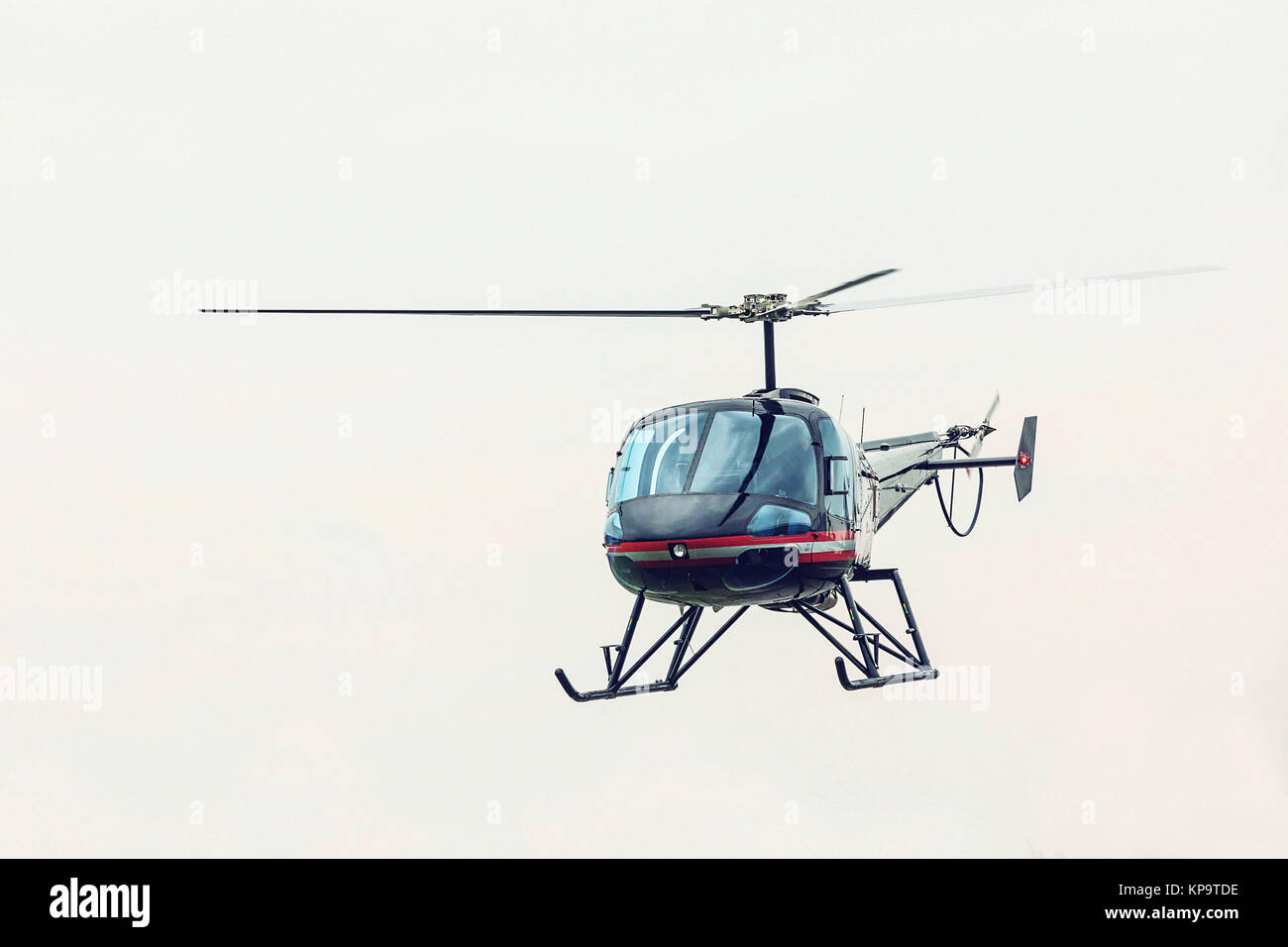 Black helicopter flying in front. Light multipurpose helicopter five