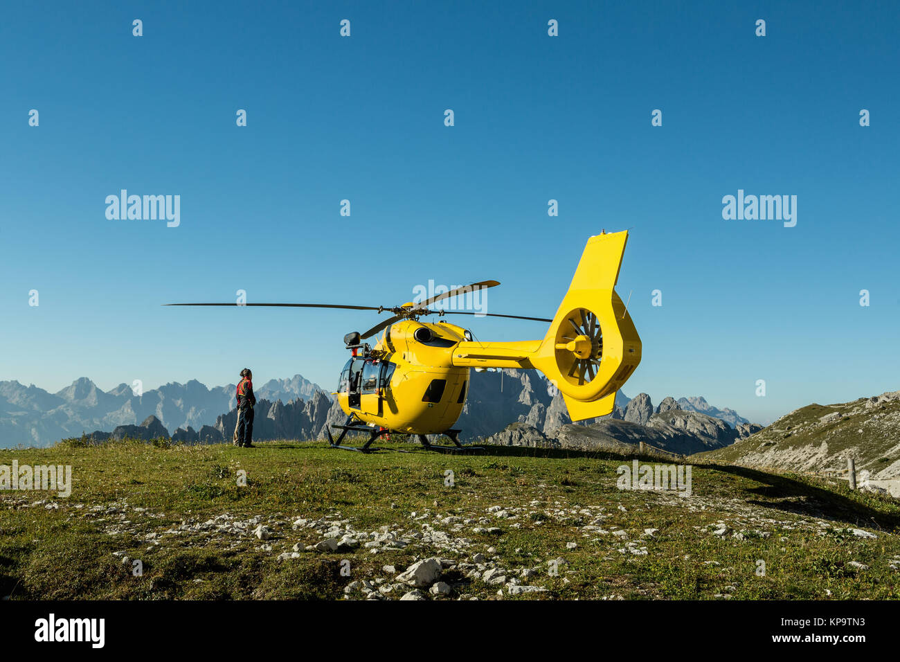 Yellow helicopter used for rescue operations, On the ground in Dolomites, Italy. Helicopter rescue Stock Photo