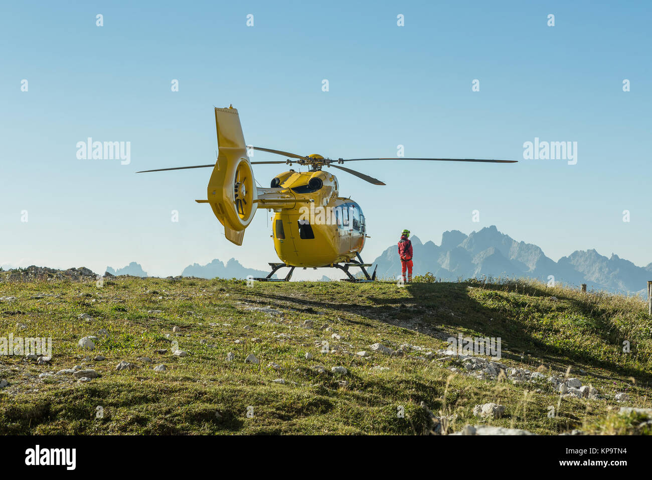 Yellow helicopter used for rescue operations, On the ground in Dolomites, Italy. Helicopter rescue Stock Photo