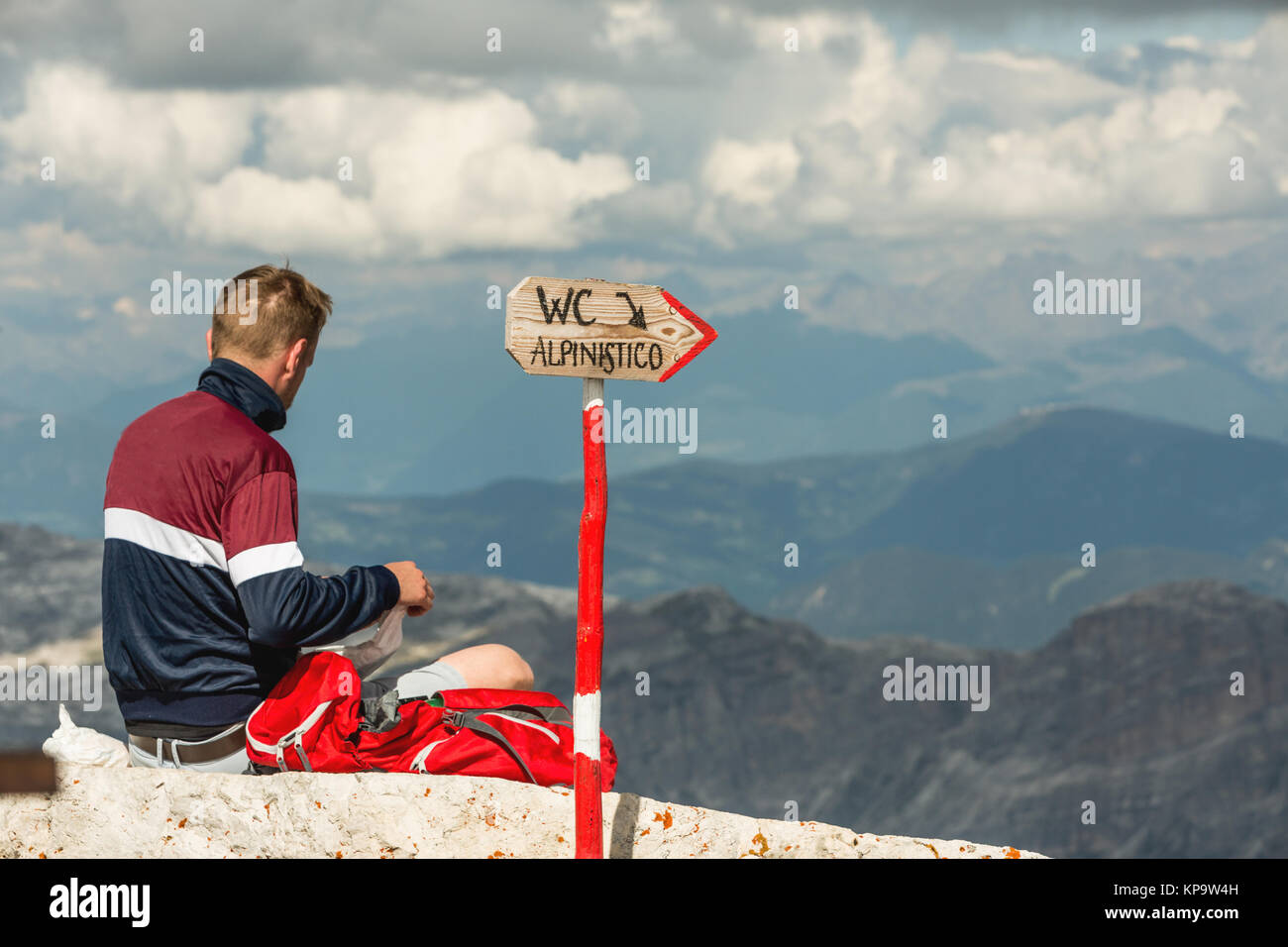 Climber resting on top Pic Boe, sign WC ALPINISTO, Dolomites, Italy Stock Photo