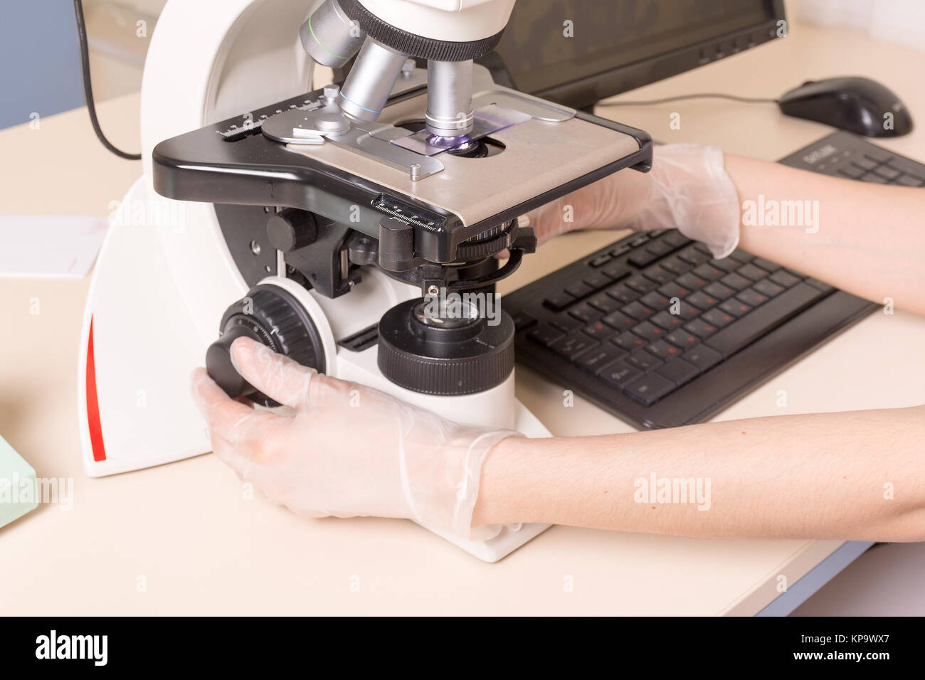 Medical or scientific researcher using a microscope in laboratory ...
