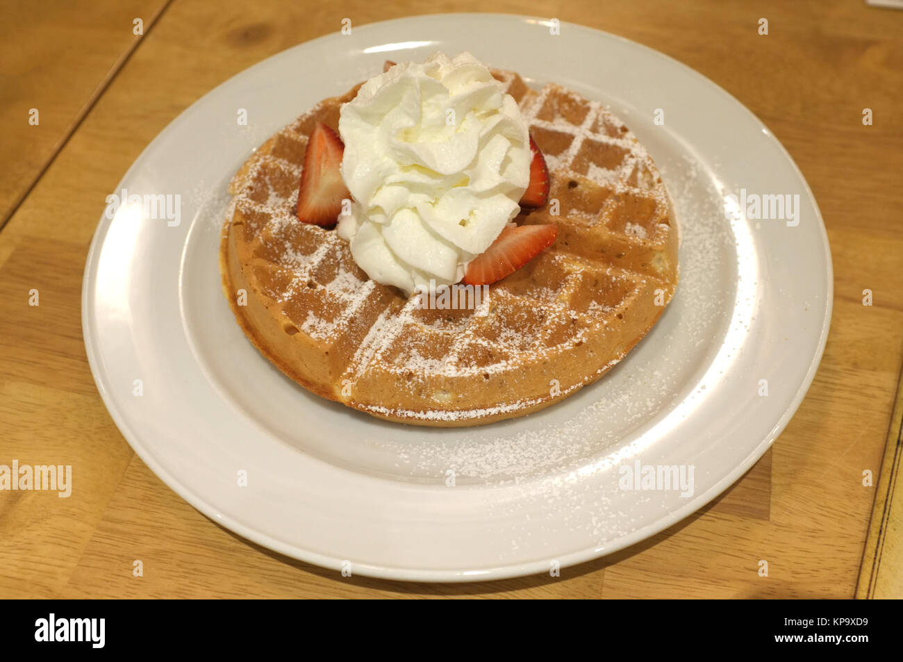Waffle with whipped cream, strawberry and icing Stock Photo - Alamy