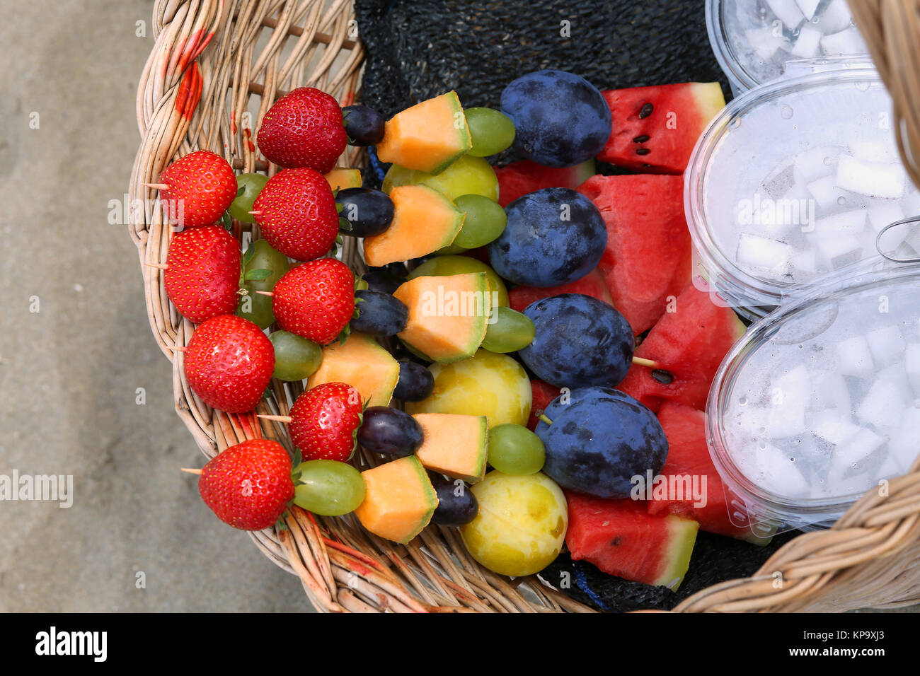 skewers of fresh fruit and coconut for sale on the beach in summer