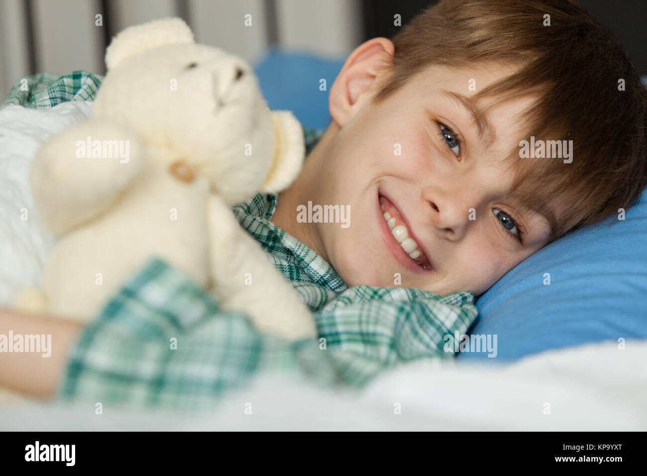 Happy Boy with his Teddy Bear Lying on his Bed Stock Photo - Alamy