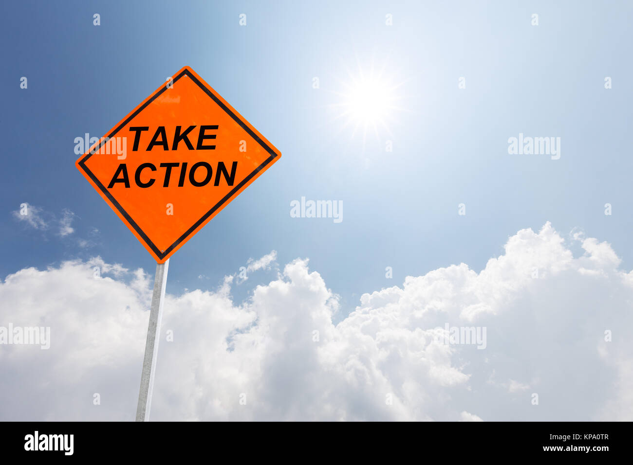 orange diamond traffic sign take action on road against blue sunny sky Stock Photo