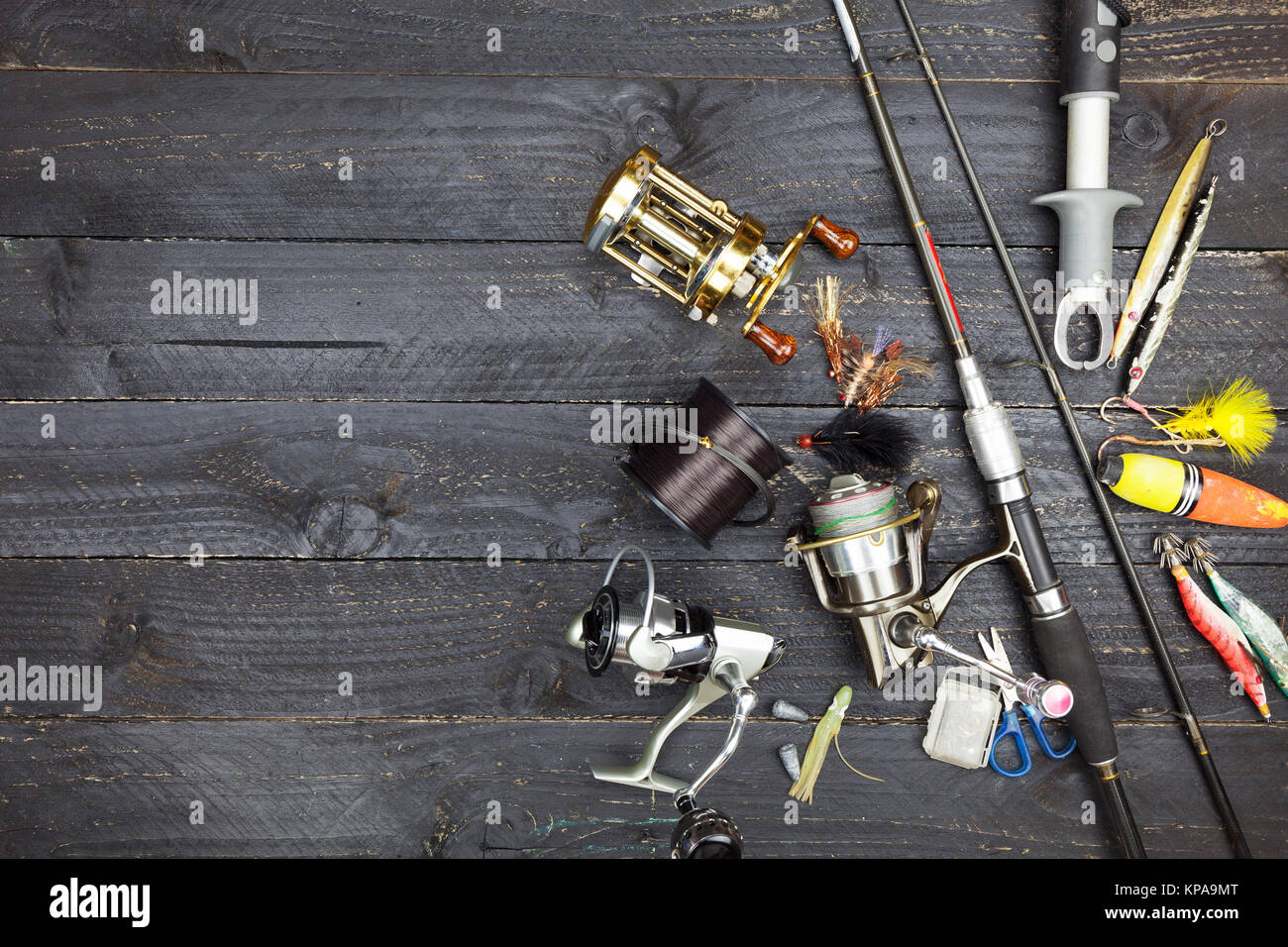 Fishing rods and reels, fishing tackle on black wooden background Stock  Photo - Alamy