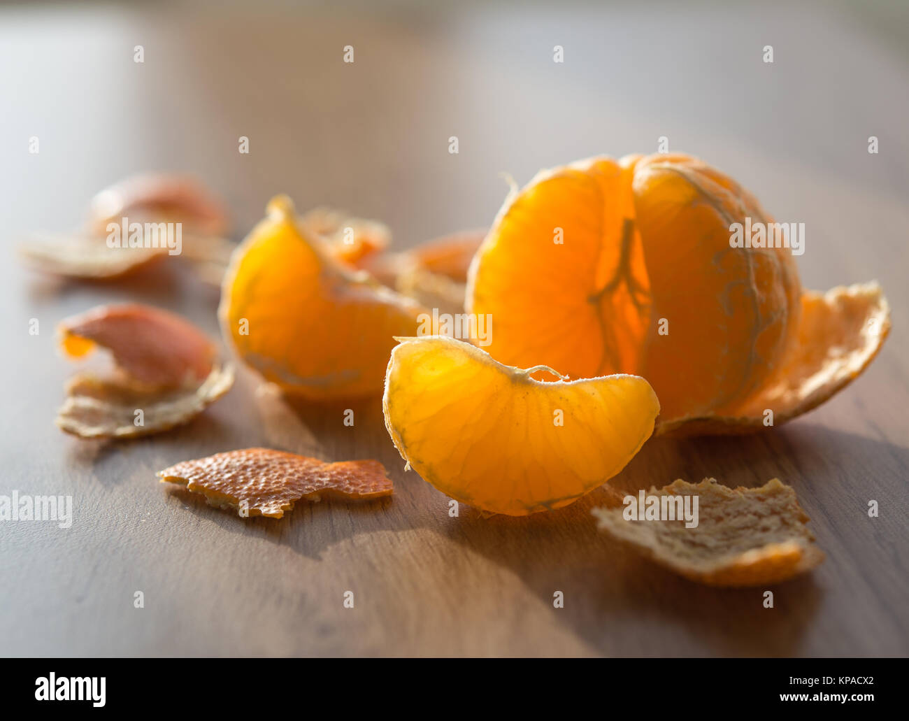 Peeled tangerine and segment backlit from the sun Stock Photo