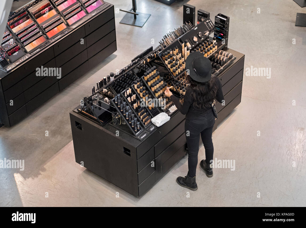 An unidentifed young lady tidies the MAC cosmetics counter at Macy's Herald Square in Manhattan, New York City, Stock Photo