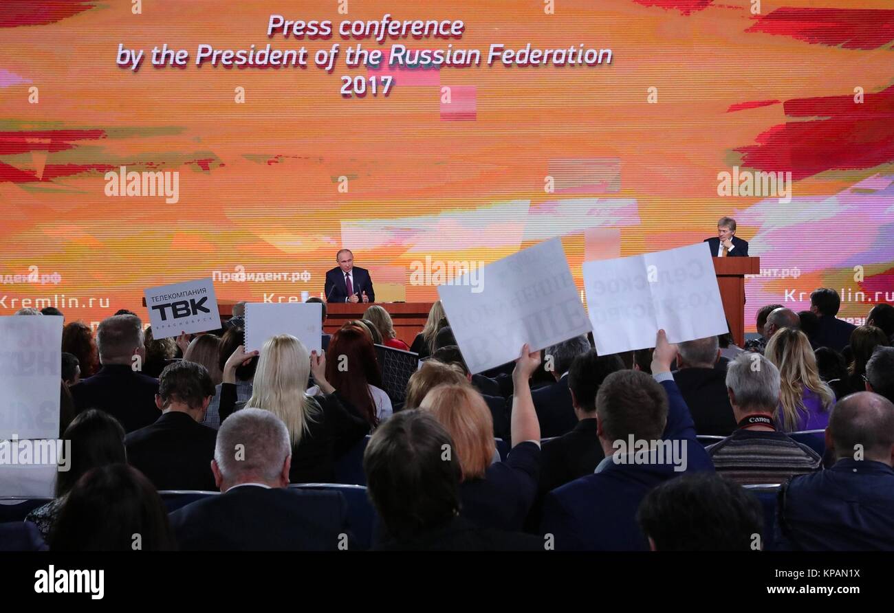 Moscow, Russia. 14th December, 2017. New organizations hold up signs to be selected for a question by Russian President Vladimir Putin during the annual press conference at the World Trade Center in Krasnaya Presnya December 14, 2016 in Moscow, Russia. Putin confirmed he will be running for re-election in the upcoming presidential elections. Credit: Planetpix/Alamy Live News Stock Photo
